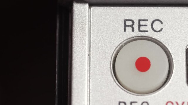 Close up of REC button with red dot pressed on silver panel