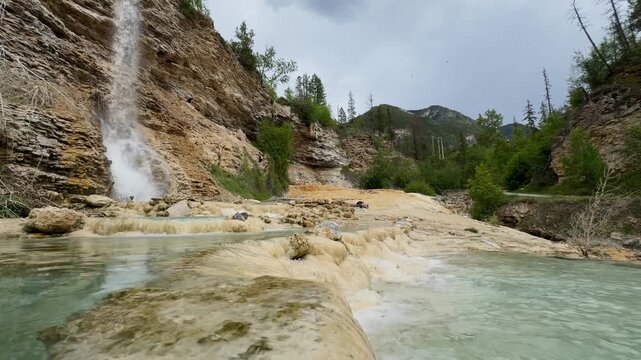 Fairmont Hot Springs waterfall cascades over travertine rock formations and mineral pools