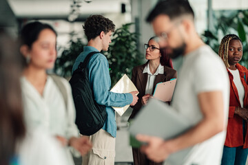 Obraz na płótnie Canvas Students and a professor collaborating in a modern university setting, focusing on learning and academic guidance