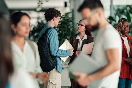 Students and a professor collaborating in a modern university setting, focusing on learning and academic guidance