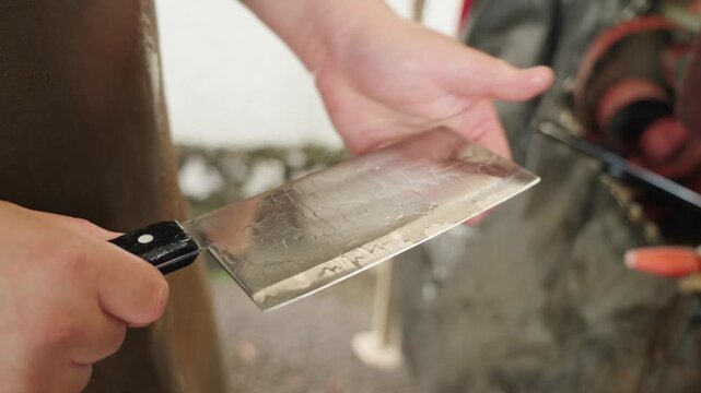 Close-up of hands inspecting a freshly cleaned Chinese cleaver knife in Malaysia, checking blade sharpness and surface quality after washing, highlighting precision and craftsmanship. UHD.