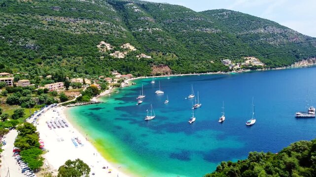 Aerial view of Mikros Gialos bay. A sheltered pebble beach surrounded by green cliffs and emerald waters, perfect summer vacation destination, Lefkada Island, Greece.