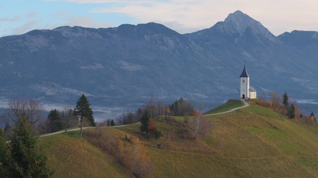 St Primus and Felician Church in Jamnik Slovenia on hill with mountains scenic landscape