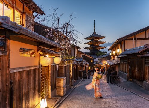 Woman in kimono in a lane, Yasaka dori historical alleyway in the old town with traditional Japanese houses, behind five-storey Yasaka pagoda of the Buddhist Hōkanji temple, evening mood, Kyoto, Japan