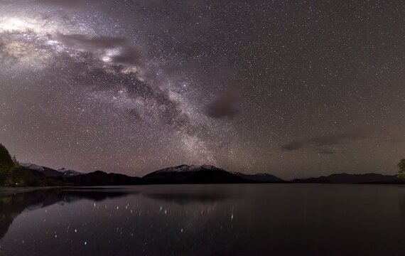 Night Scene, Wanaka lake with stars and Milky Way, stars mirroring in the water, Glendhu Bay, Otago, Southland, New Zealand