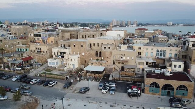 Aerial reveal over the historic stone buildings of Akko, Old city of Acre, Isreal during beautiful twilight.