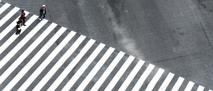 Shibuya Crossing, intersection, three people cross long crosswalk, Shibuya, Udagawacho, Tokyo, Japan