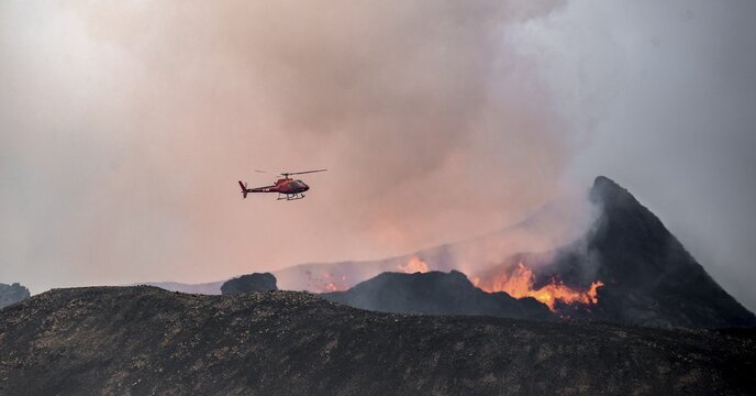 Helicopter flying over smoking active volcanic crater, glowing lava, volcanic eruption, active table volcano Fagradalsfjall, Kr&yacute;suv&iacute;k volcanic system, Reykjanes Peninsula, Iceland