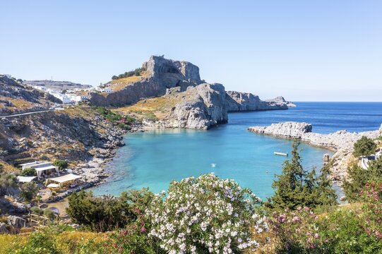 Turquoise sea and sandy beach, Acropolis of Lindos, ancient citadel on a steep cliff, Lindos, Rhodes, Dodecanese, Greece