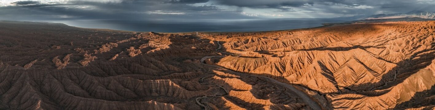 Evening mood, Canyon runs through landscape, Issyk Kul Lake, Dramatic barren landscape of eroded hills, Badlands, Canyon of the Forgotten Rivers, Issyk Kul, Kyrgyzstan
