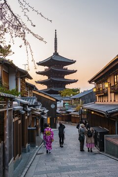 Pedestrian with kimono, Yasaka dori historical street in the Old Town with traditional Japanese houses, behind five-storey Yasaka pagoda of the Buddhist Hōkanji Temple, evening mood, Kyoto, Japan