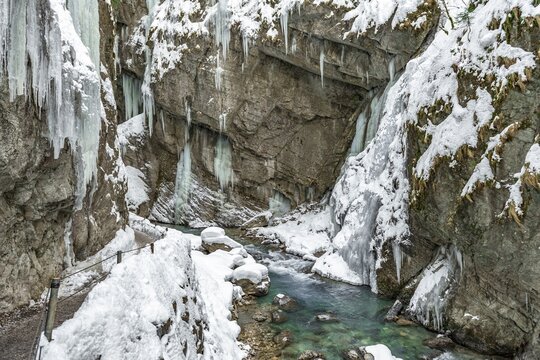 Path to Partnach wild river in the Partnach gorge with icicles and snow in winter, near Garmisch-Partenkirchen, Upper Bavaria, Bavaria, Germany