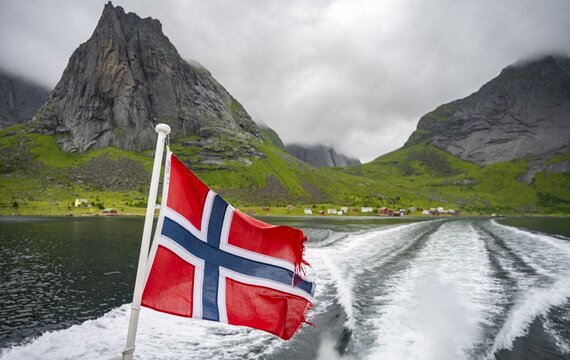 Norwegian flag at the ferry from Reine to Vinstadt on the Reinefjord, Lofoten, Nordland, Norway