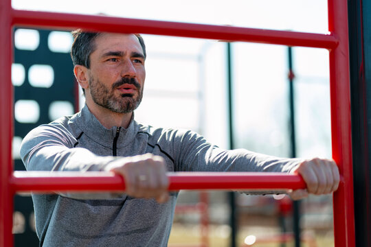 Man exercising calisthenics on outdoor parallel bars