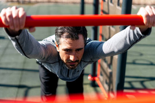 Man exercising on outdoor fitness equipment