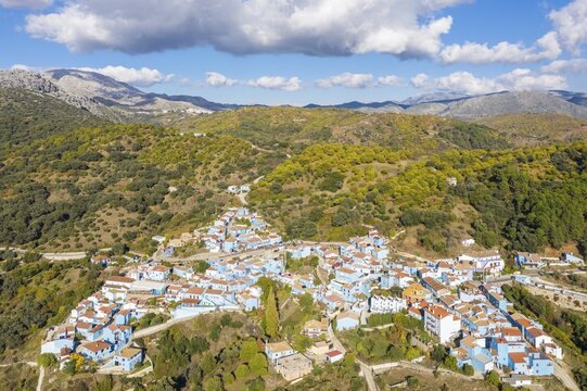 The village of J&uacute;zcar above the Genal river valley, the houses of this former White Village have been painted in smurf-blue to celebrate the premiere of the Smurfs movie, aerial view, drone shot, Serran&iacute;a de Ronda, M&aacute;laga province, Andalusia, Spain
