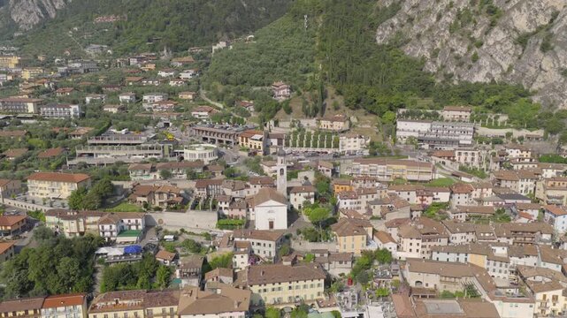 Aerial drone footage featuring a smooth forward flight toward the church in Limone sul Garda on the shores of Lake Garda. The shot captures the charming village, surrounding mountains 6k to 4K 60fps