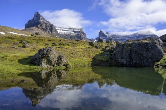 Mountains S&uacute;la St&ouml;pull and Tindfell reflected in a lake, rockfall area St&ouml;ru&eth;, Borgarfj&ouml;r&eth;ur, Austurland, Iceland