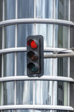 Red traffic light in front of house facade, Berlin, Germany