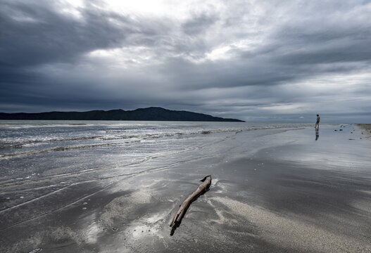 Beach Waikanae Beach with dramatic clouds, behind Kapiti Island, Waikanae, North Island, New Zealand