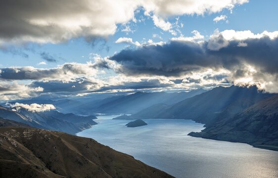 Sunbeams shining through clouds, view of Lake Wanaka in evening light, lake and mountain landscape, view from Isthmus Peak, Wanaka, Otago, South Island, New Zealand