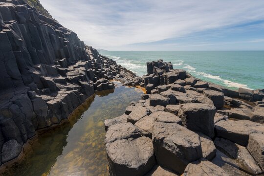 Water gathering between rocks, Roman Bath, Hexagonal basalt column by the Sea, Blackhead, Dunedin, Otago, South Island, New Zealand