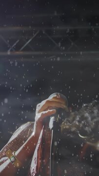 Vertical video: Singer singing on music stage, cue sparking rain, whipping hair with mic for drama