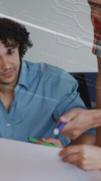 Vertical video: Team collaborating, one reaching and marking sheet while circuit overlay mapping IT