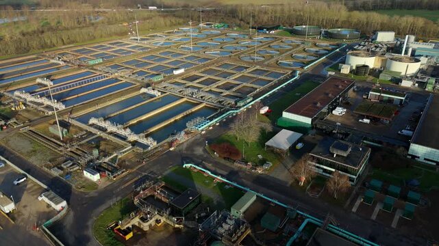 Aerial view of a Milton Keynes sewage treatment plant featuring circular clarifying tanks and settling pools for aerobic digestion and water purification.