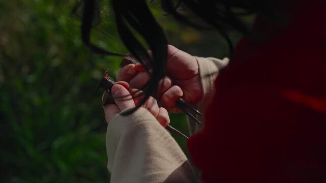 closeup of Jesus Christ in red sash gripping iron crucifixion nails in both hands