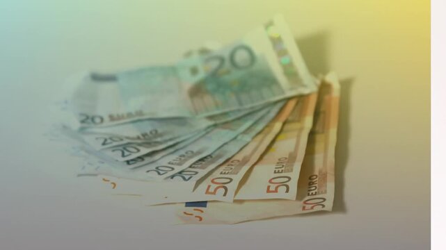 Animation of close up of euro bills falling against yellow gradient background