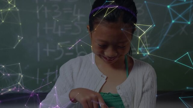 Animation of asian schoolgirl smiling and using tablet over shapes