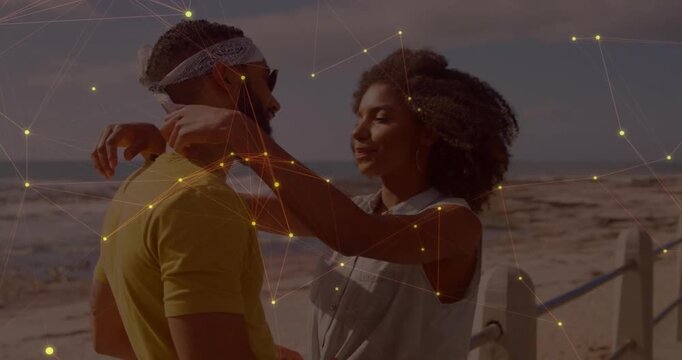 Man gifting pendant, woman taking and fastening, embracing, particles over couple and sea, travel