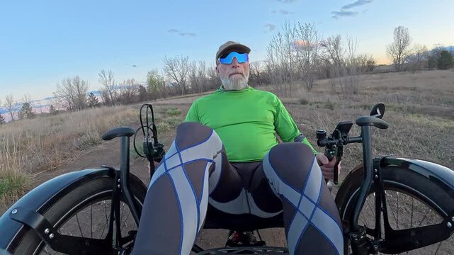 Senior cyclist is riding a full suspension recumbent on a rough gravel trail in northern Colorado - Kyger Open Space