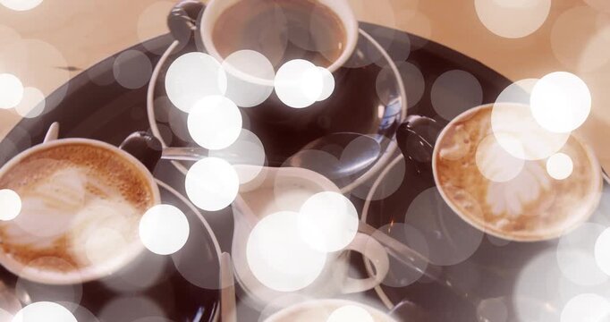 At start tray carrying four cups and pitcher rotating and bokeh drifting highlighting cafe service