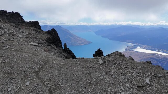 Flyover rugged mountain ridge to reveal Lake Wakatipu at Queenstown