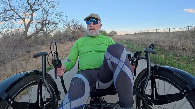Senior cyclist is riding a full suspension recumbent downhill on Poudre River Trail in northern Colorado near Windsor