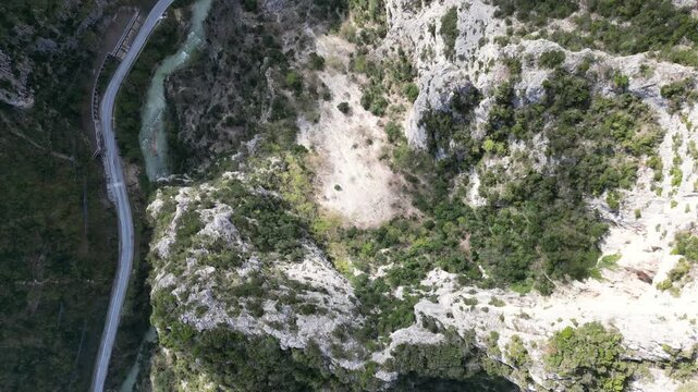 Aerial drone footage over Frasassi Gorge, Italy: rocky cliffs, green vegetation and dramatic natural landscape. Ideal for travel, nature and geological projects.