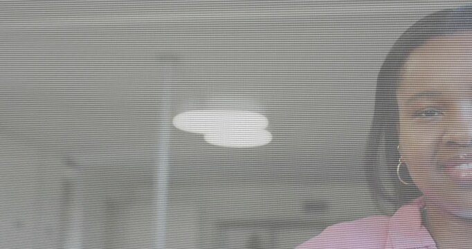 Female staff shifting into frame, smiling, reacting to cue, pink shirt, hoop earring in office