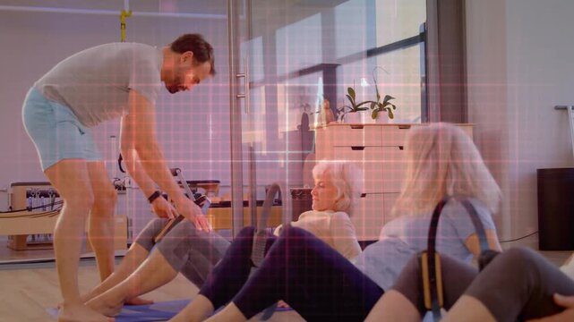 Pilates coach leaning adjusting form cueing women pressing rings on mats grid not altering class