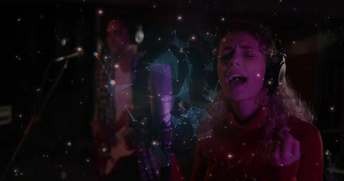 Female vocalist singing into condenser mic for recording, orb pulsing over mic revealing guitarist