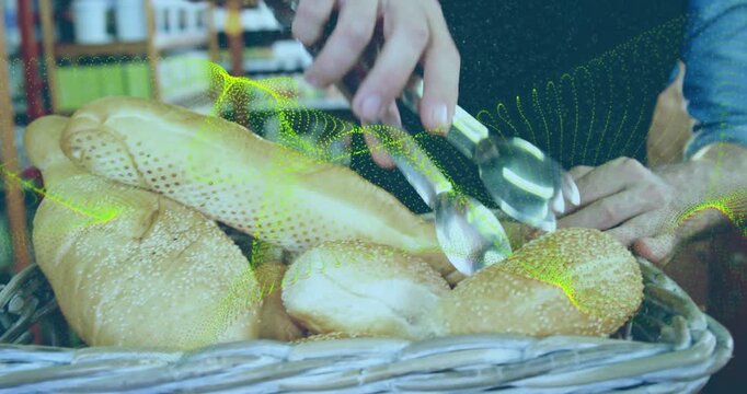 Buyer using tongs initiating selection to serve, bakery staff holding rim, loaves shifting