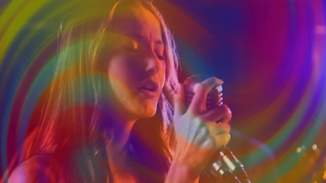 Breathing into retro mic, singer singing music as guitarist playing, rainbow rings overlaying frame