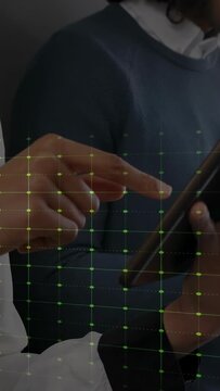 Vertical video: Team tapping tablet, finger making green waveform tracing motion on grid for tech