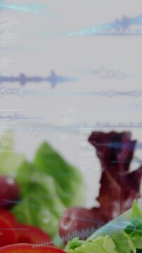 Vertical video: Lens panning up revealing salad, blue waveform scrolling, focus sharpening for ads