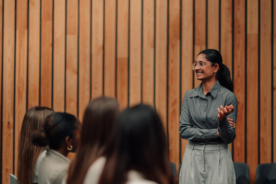 Coach speaking to diverse student audience, sharing knowledge and expertise at a professional seminar or conference