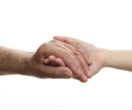 Grandfather and his granddaughter holding hands on white background, closeup