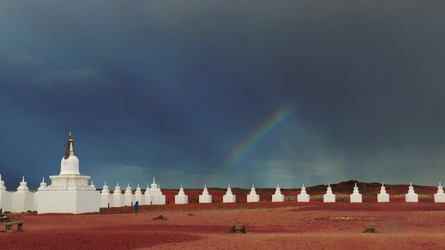 Buddhist ritual structures stupa in the Gobi desert, Mongolia. Architectural complex of Shambala. White stupas on the background of a picturesque cloudy sky on a summer day.