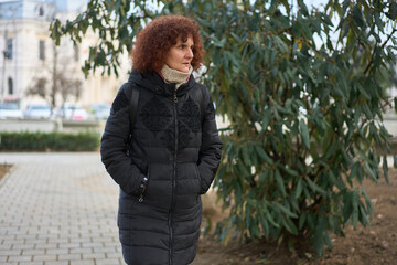 Mature woman in winter coat in city park © Xalanx