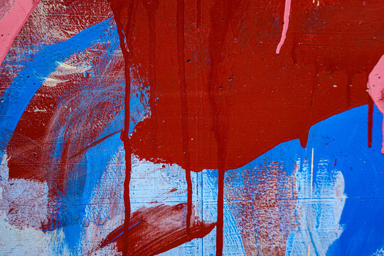 Red blue pink paint strokes on old white grunge wall background outdoors. Abstract urban background